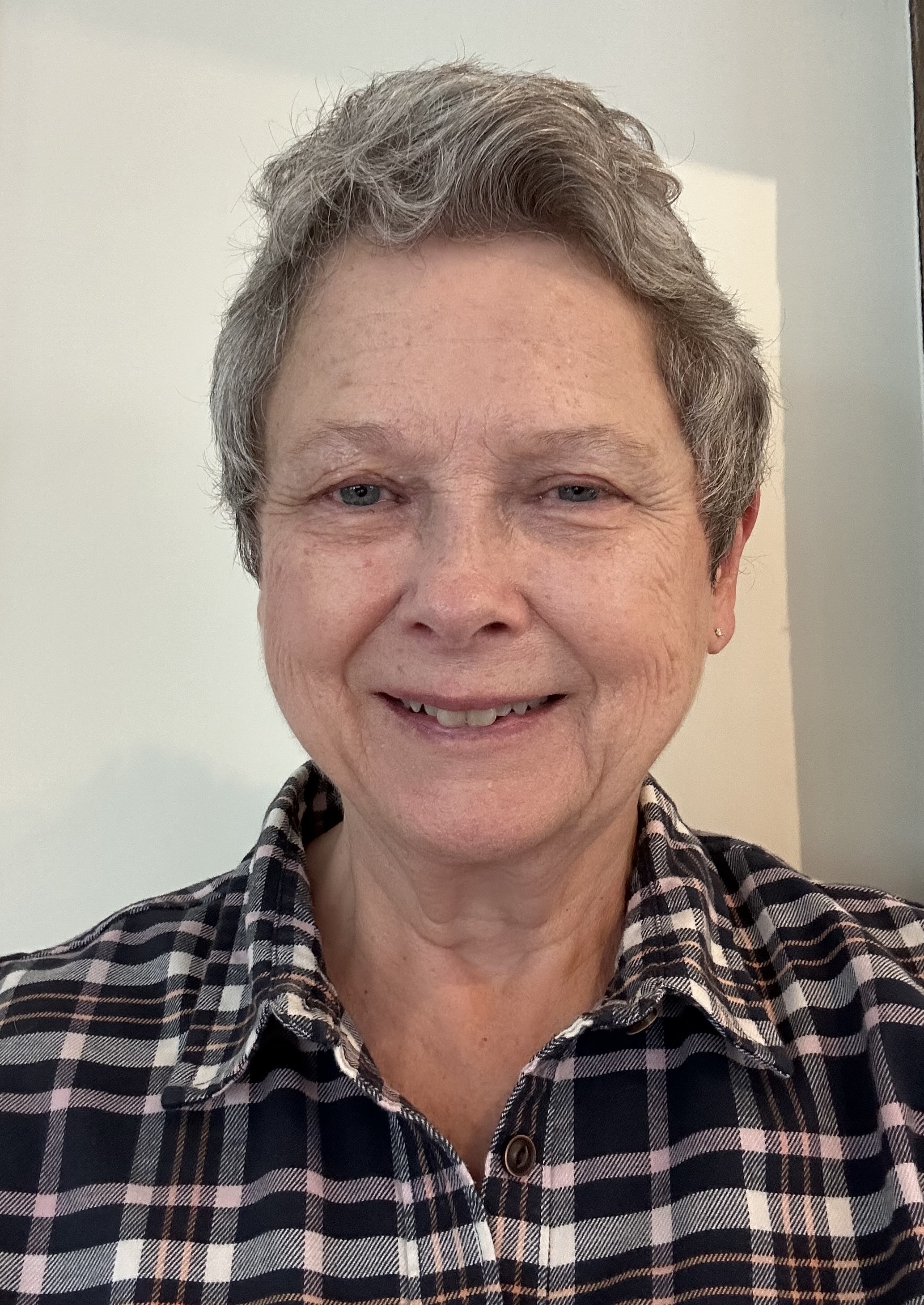 woman, short grey hair and plaid shirt, nice smile