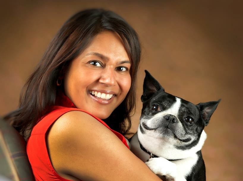 dark haired female, beautiful smile, black and white dog in her arms also with a big smile.