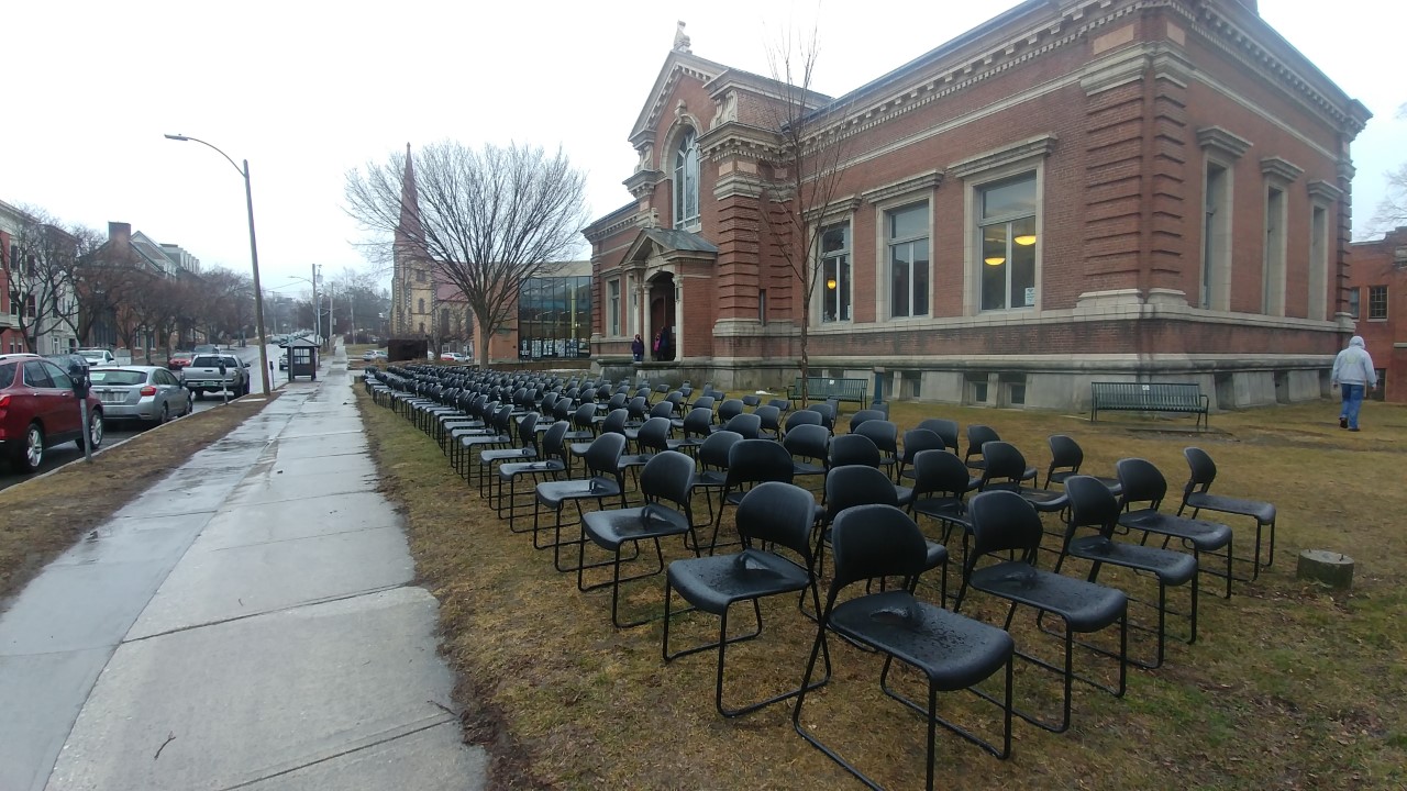 several empty chairs in front of brick building March 2021