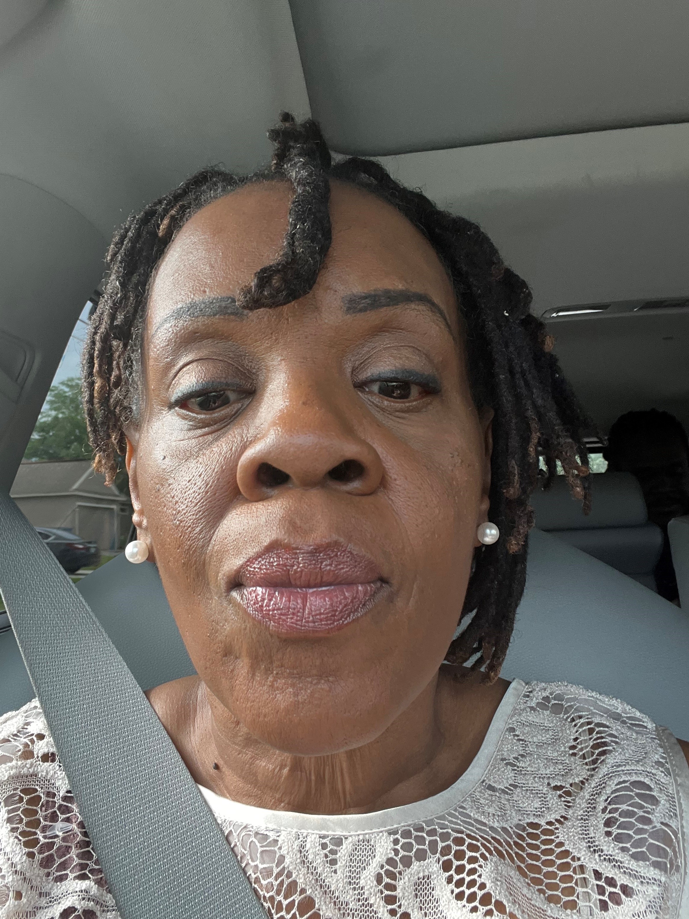 black woman with short braids, white top and seatbelt strap