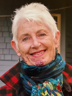 female, red and black checkered jacket. White hair, nice smile